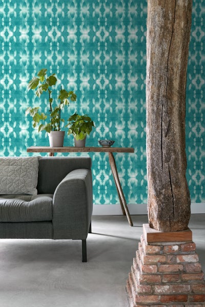 Einrichtungsidee mit Sofa, Holztisch, Zimmerpflanzen und gemusterter Tapete