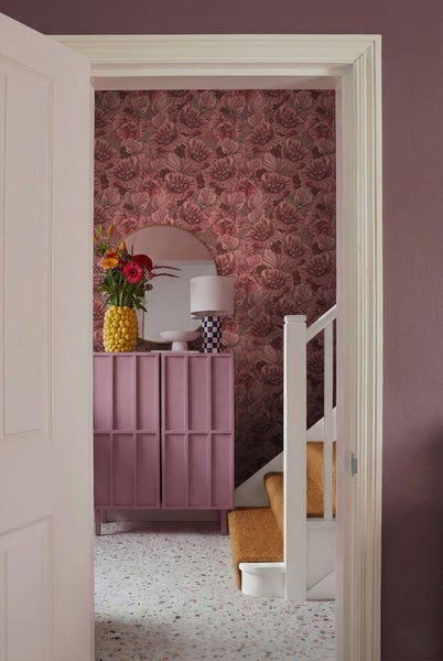 Flur mit Blumentapete, Kommode und Treppe
