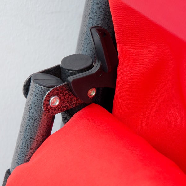 Detailansicht eines Campingstuhls mit Metallrahmen und roter Stoffbespannung