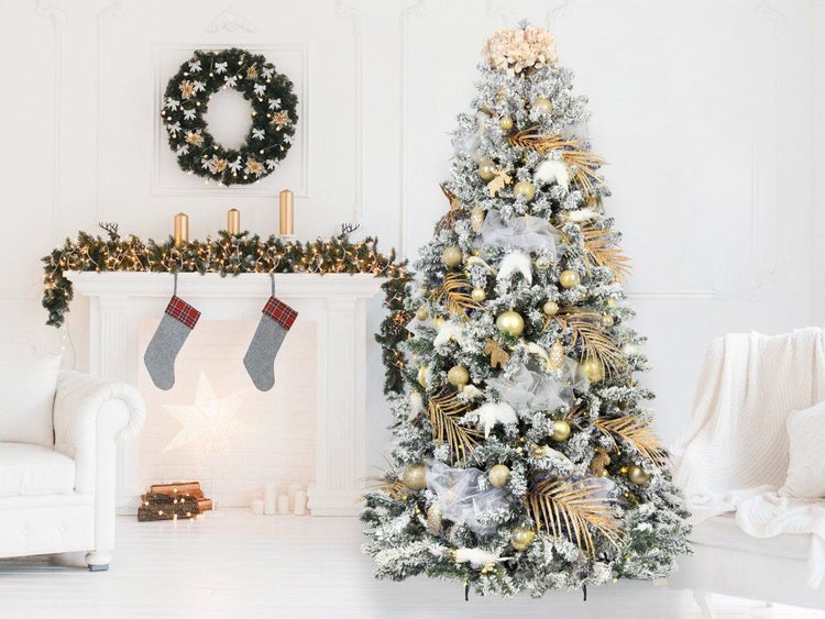 Weihnachtlich geschmückter, künstlicher Tannenbaum mit Dekoration und beleuchtetem Kaminzimmer.