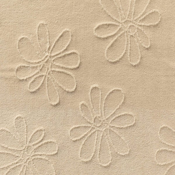 Nahaufnahme eines weichen Badteppichs mit einem reliefartigen Blumenmuster.