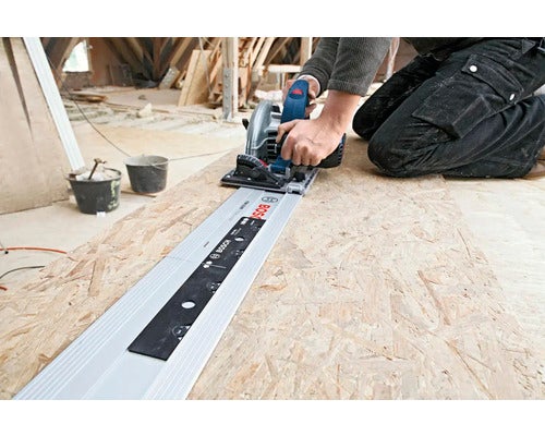 Anwender schneidet Holzplatte mit Bosch Tauchsäge und Führungsschiene