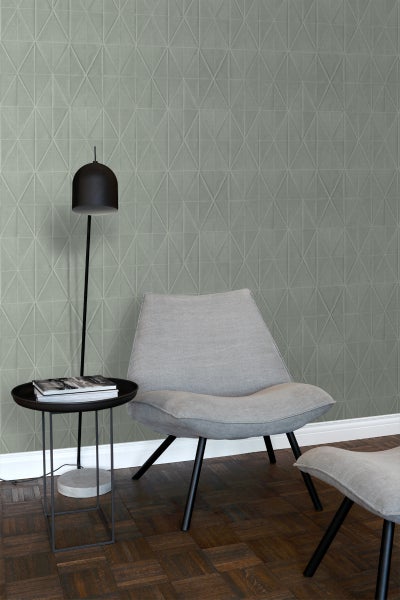 Raumgestaltung mit geometrischer Tapete, Sessel, Hocker und Stehleuchte