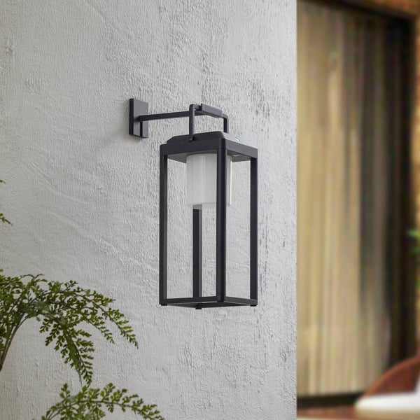 Schwarze Außenwandleuchte im modernen Laternendesign mit rechteckigem Rahmen, montiert an einer strukturierten Wand.