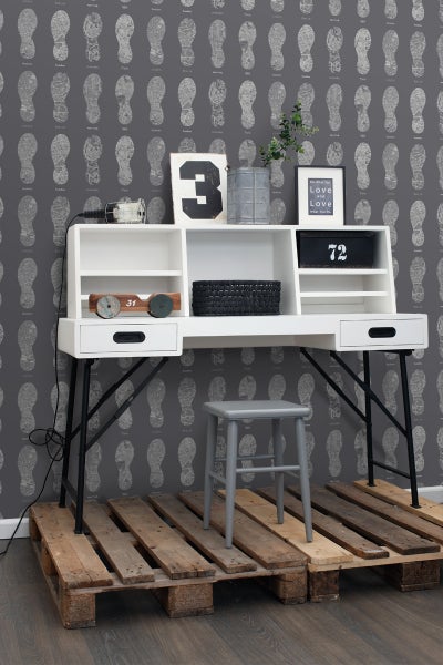 Schreibtisch mit Ablagefächern, Metallbeinen und Hocker auf einer Holzpalette vor einer gemusterten Tapete