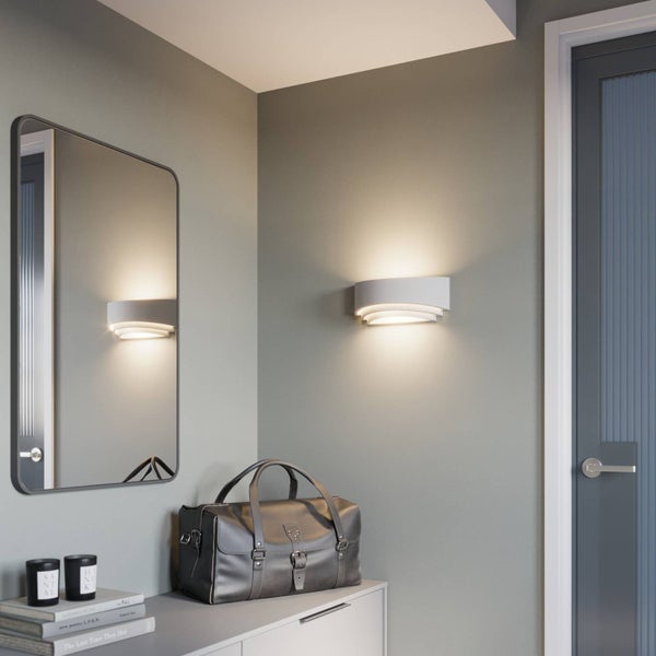 Detailaufnahme eines weißen mehrstufigen Deckenprofils mit integrierter indirekter Beleuchtung für ein modernes Innendesign.