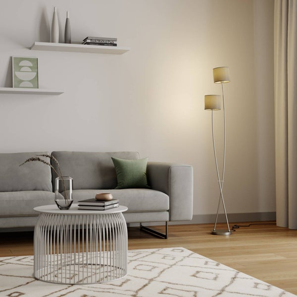 Wohnzimmer mit Sofa, Couchtisch und Stehlampe mit zwei Lampenschirmen