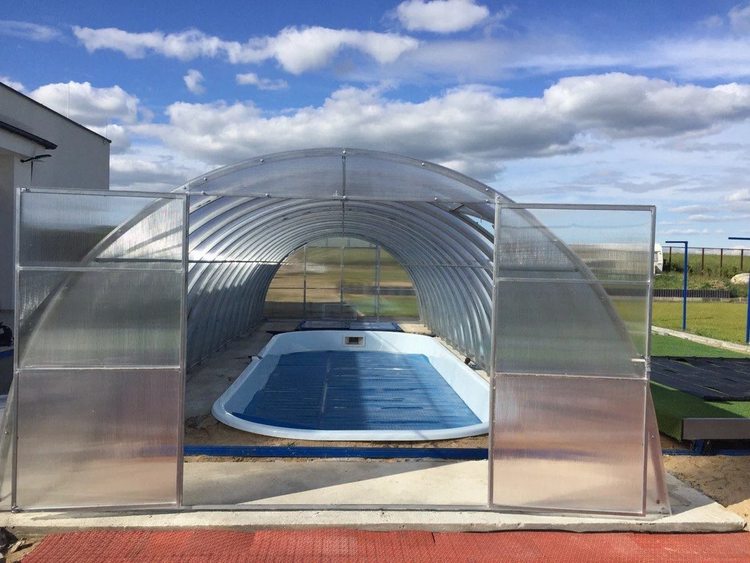 Schwimmbadüberdachung mit geöffneten Türen über einem Pool