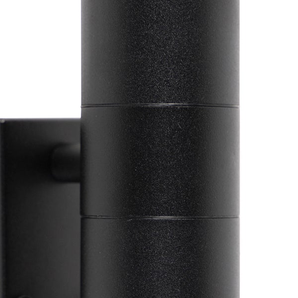 Detailaufnahme einer schwarzen zylindrischen Wandleuchte mit strukturierter Oberfläche.