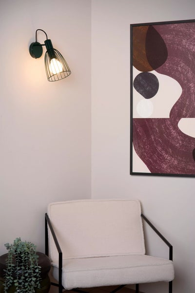 Innenraum mit Sessel, Wandleuchte und gerahmtem Bild