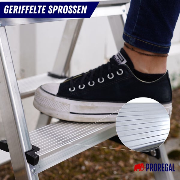 Detailaufnahme einer Aluminiumleiter mit geriffelten Sprossen unter einem Fuß