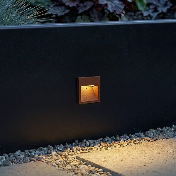 Quadratische Wandeinbauleuchte für den Außenbereich mit warmweißem Licht in einer dunklen Mauer