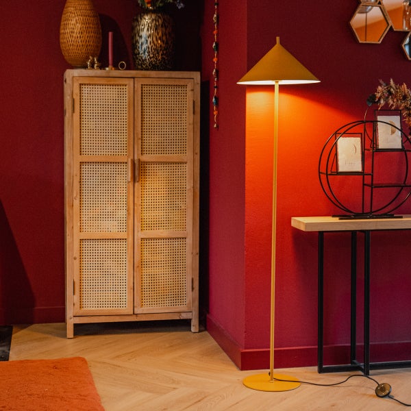 Wohnzimmer mit Holzschrank, Stehlampe und Tisch