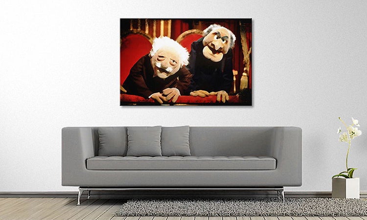 Wandbild auf Leinwand mit Statler und Waldorf aus der Muppet Show über einem grauen Sofa in einem modern eingerichteten Wohnzimmer.