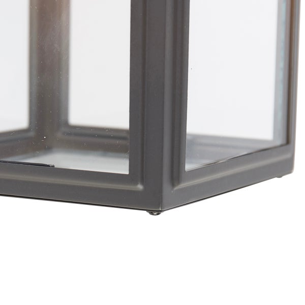 Detailansicht der unteren Ecke einer Laterne aus Metall und Glas.