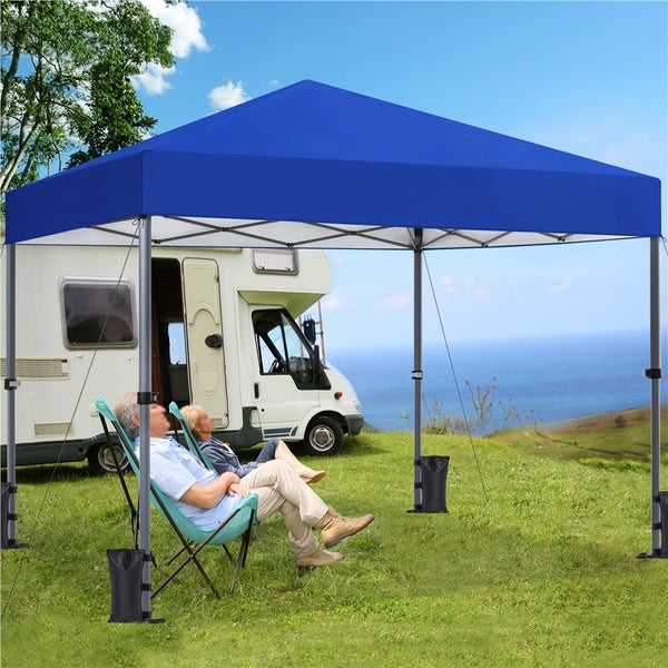 Blauer Pavillon mit zwei Personen im Freien, Wohnmobil im Hintergrund