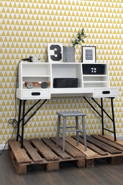 Schreibtisch mit Regalen, Schubladen und schwarzem Metallgestell auf einer Holzpalette mit grauem Hocker