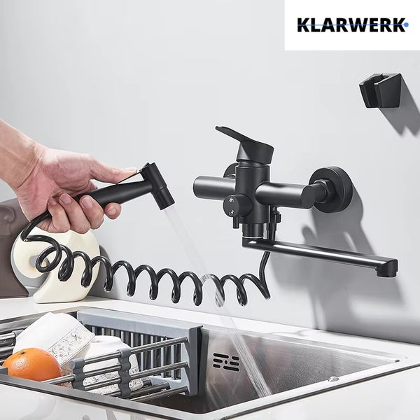 Wandmontierte Küchenarmatur in Schwarz von Klarwerk mit schwenkbarem Auslauf und Brause an Spiralschlauch über einer Spüle. Klarwerk Logo.
