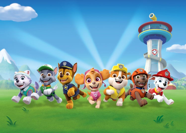 Helle Szene mit Paw Patrol Charakteren Everest, Rocky, Chase, Skye, Rubble, Zuma und Marshall auf einer Wiese mit der Zentrale im Hintergrund.