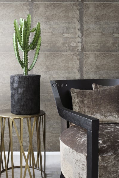 Dekoratives Interieur mit Kaktus in einem Topf auf einem Beistelltisch neben einem Sessel.