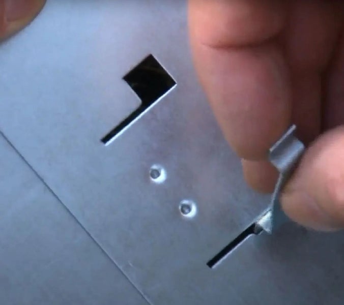 Detailansicht einer Metallplatte mit Aussparungen und Halteelement