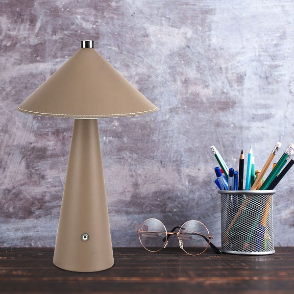 Dekorative Lampe mit kegelförmigem Lampenschirm auf einem Schreibtisch
