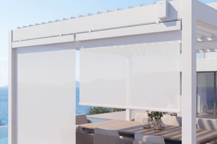 Pergola mit integriertem Sichtschutzrollo auf einer Terrasse mit Esstischgarnitur und Blick auf das Meer.
