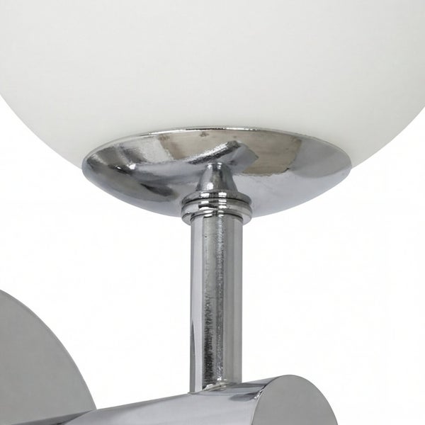 Detailaufnahme einer Leuchte mit Schirm aus Glas und einem Gestell aus Metall.