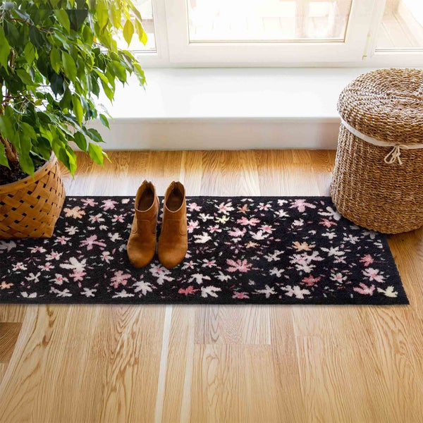 Szene mit einem Teppichläufer mit Blumenmuster, Stiefeln, einer Pflanze und einem Korb