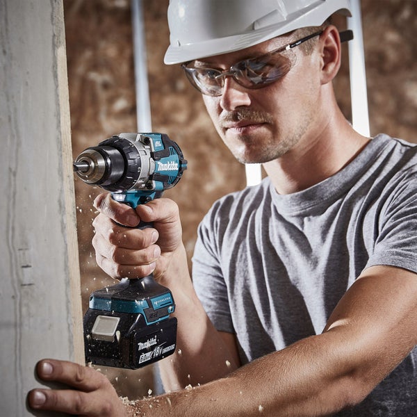 Ein Handwerker bohrt mit einer Makita Akku-Bohrmaschine in ein Holzbrett.