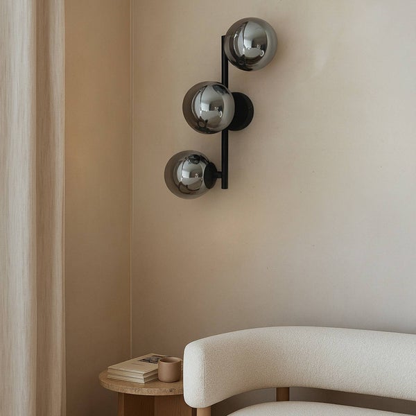 Wandleuchte mit drei Glasschirmen im Wohnzimmer