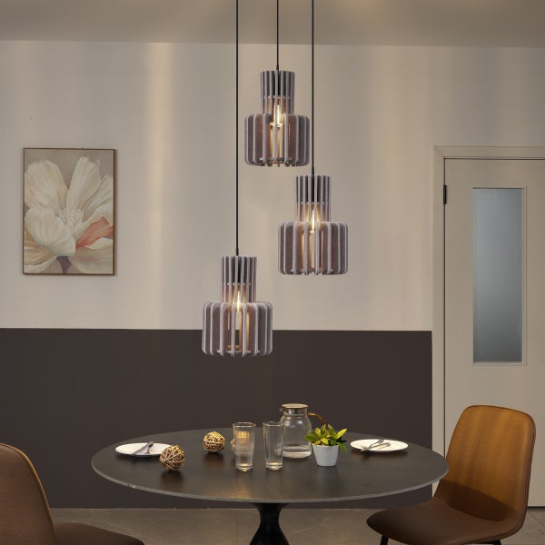 Dreiflammige Pendelleuchte mit grauen Filzlamellen über einem dunklen runden Esstisch in einem modern eingerichteten Esszimmer.