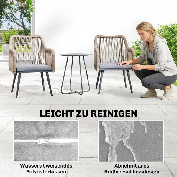 Gartenmöbel Set mit zwei Sesseln und Tisch auf Terrasse. Frau zeigt wasserabweisende und abnehmbare Polyesterkissen mit Reißverschluss.