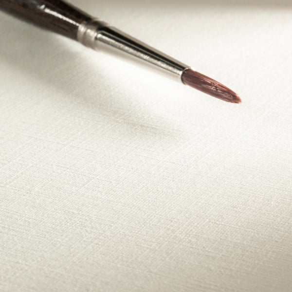 Künstlerpinsel mit feiner Spitze auf strukturierter Leinwand zum Malen.