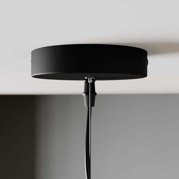 Schwarze Deckenrosette für Pendelleuchten mit Kabelauslass an einer Decke montiert.