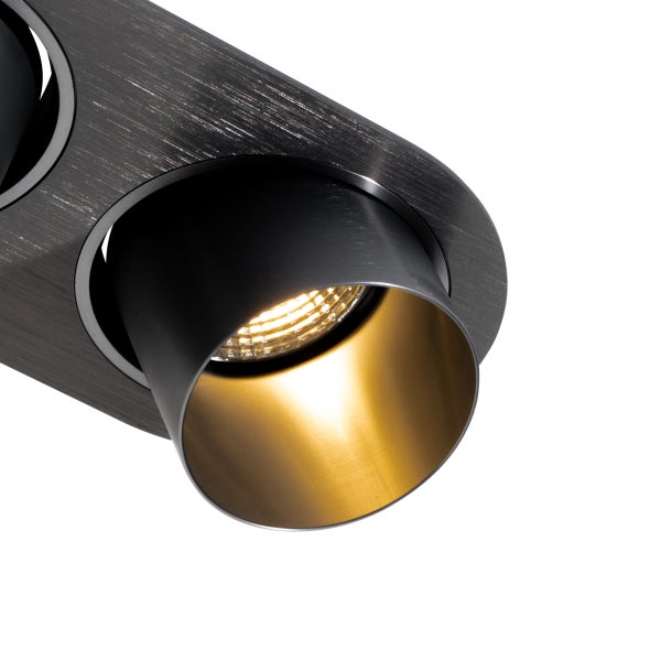 Deckenstrahler aus gebürstetem dunklem Metall mit goldener Innenseite und eingeschaltetem Licht.