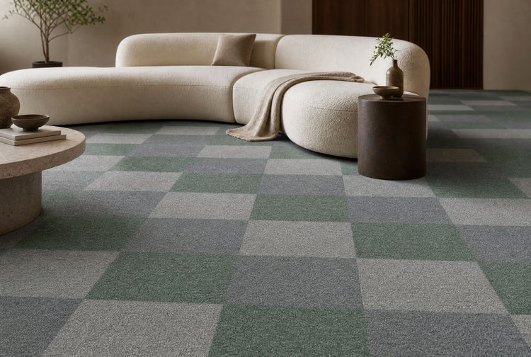Modernes Wohnzimmer mit Teppichfliesen im Schachbrettmuster, geschwungenem Sofa und Couchtisch in hellem, minimalistischem Ambiente.