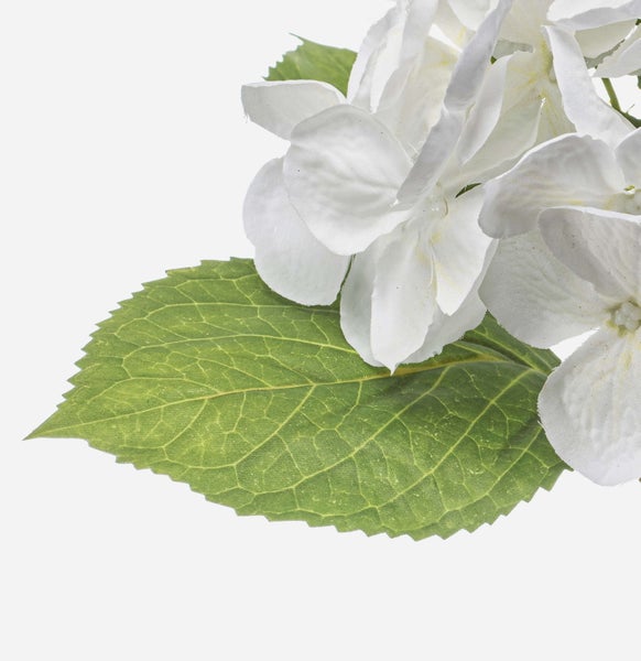Künstliche Blume mit weißen Blütenblättern, grünem Blütenstand und grünen Blättern am Stiel.