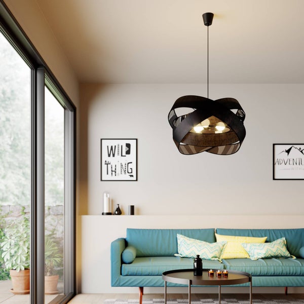 Moderne schwarze Pendelleuchte mit verflochtenem Schirm in einem hellen Wohnzimmer mit blauem Sofa und großem Fenster.