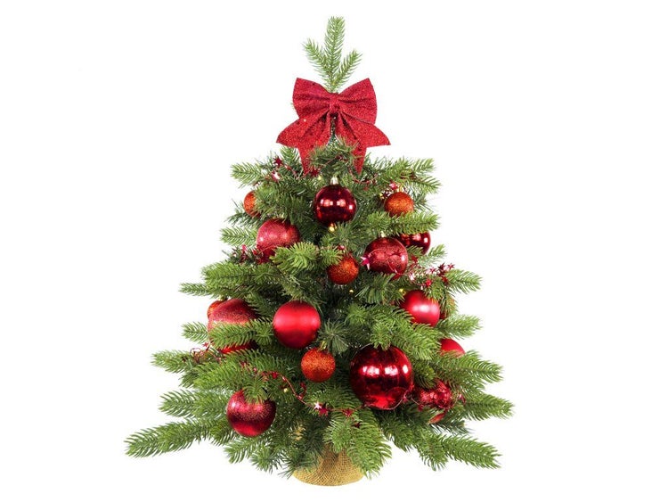 Künstlicher Miniatur Weihnachtsbaum mit rotem Weihnachtsschmuck und Schleife im Jutesack als festliche Weihnachtsdekoration.