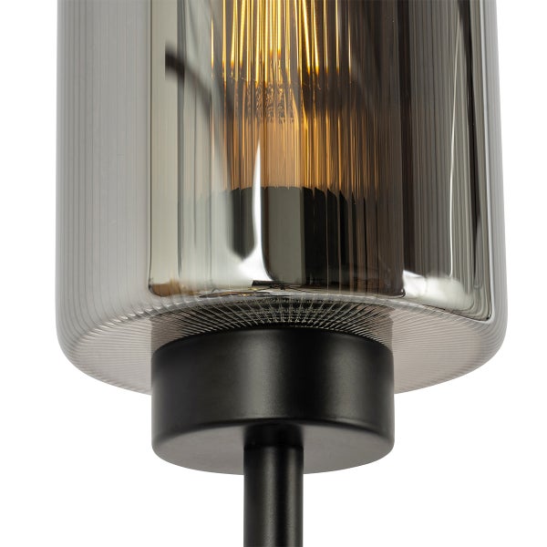 Detailaufnahme einer Tischleuchte mit geriffeltem Glas und schwarzem Fuß.