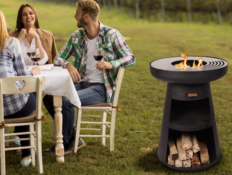 Szene im Freien mit Menschen an einem Tisch und einer Feuersäule