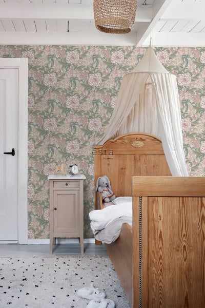 Vliestapete mit Blumenmuster im Vintage-Stil in einem hellen Kinderzimmer mit Holzbett, weißem Baldachin, Nachttisch und Esta Home Logo.