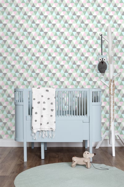 Kinderzimmer mit blauem Kinderbett, dreieckiger Tapete und Spielzeug