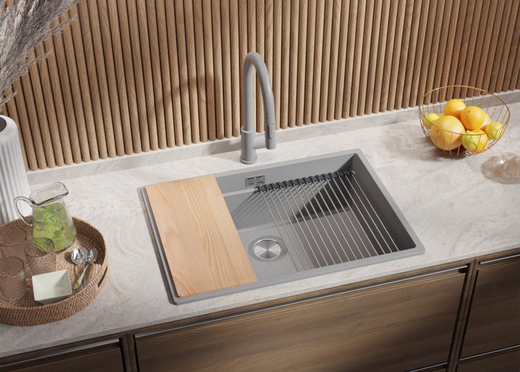 Küchenszene mit Spültisch, Armatur, Schneidebrett und Abtropfgestell.