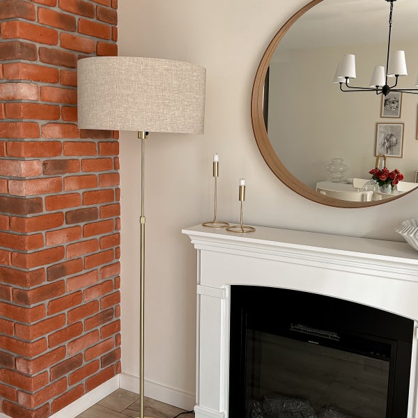 Innenaufnahme mit Ziegelwand, Stehlampe, Spiegel und Kamin
