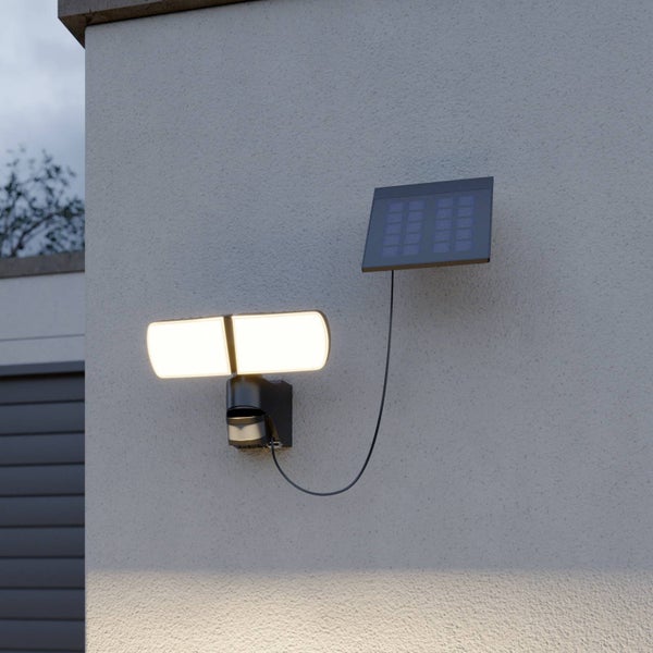 Solarbetriebener LED-Außenstrahler mit Bewegungsmelder und separatem Solarpanel, montiert an einer Wand.
