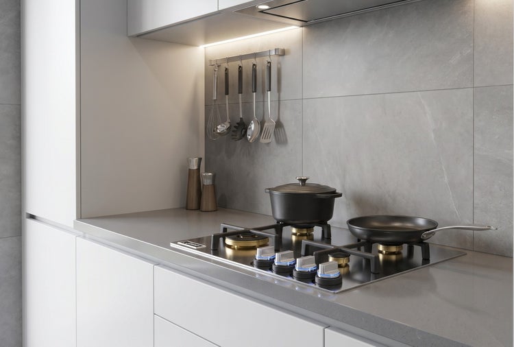 Moderne Küchenzeile mit Gaskochfeld, Kochtopf und Pfanne vor einer Fliesenwand mit Küchenutensilienleiste.