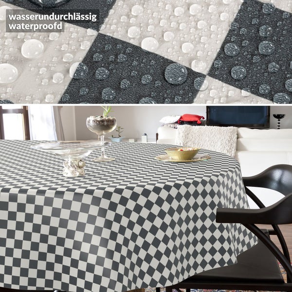 Wasserdichte Tischdecke mit Karomuster auf einem runden Tisch im Wohnzimmer. Die Detailaufnahme zeigt Wasserperlen auf der Oberfläche.