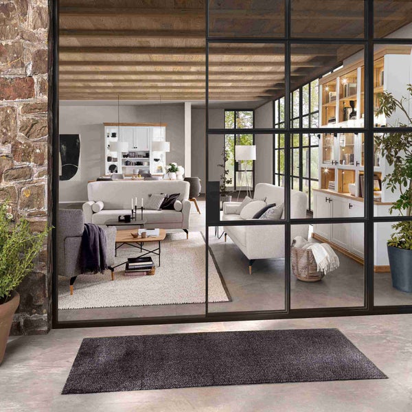 Heller und geräumiger Wohnbereich mit Sofas, Sesseln und Bücherregal